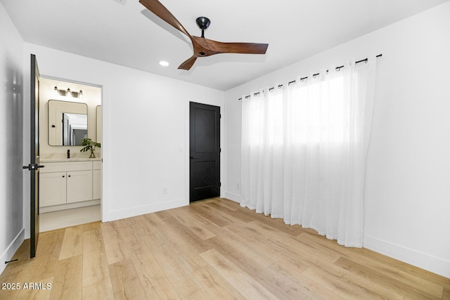 unfurnished bedroom with sink, light hardwood / wood-style flooring, ceiling fan, and ensuite bathroom