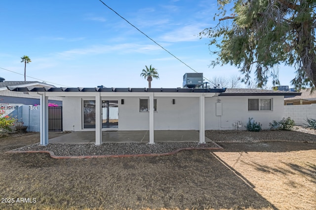 rear view of property with cooling unit and a patio area