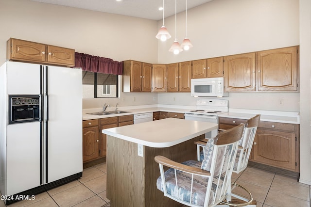 kitchen featuring a breakfast bar, white appliances, a kitchen island, and light tile patterned flooring