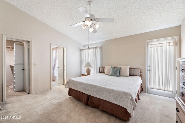 bedroom featuring ceiling fan, a spacious closet, a textured ceiling, lofted ceiling, and light carpet