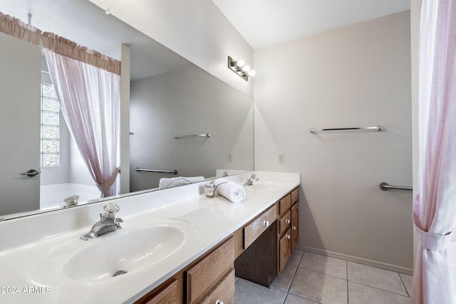 bathroom with tile patterned flooring, vanity, and a bathing tub