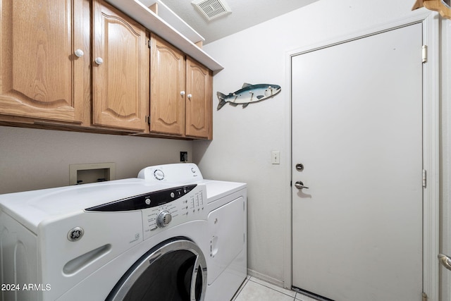 laundry room with cabinets, independent washer and dryer, and light tile patterned floors