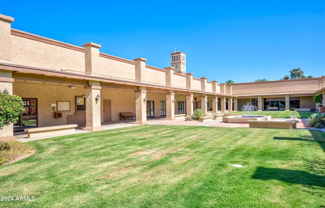 rear view of house featuring a lawn and a patio