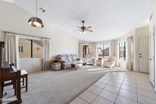 tiled living room with a textured ceiling, vaulted ceiling, and ceiling fan