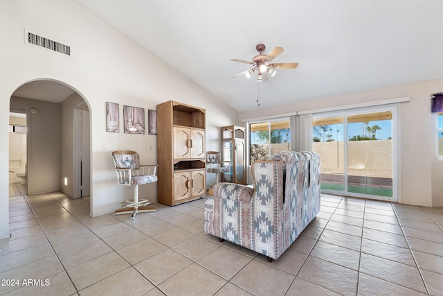 tiled living room featuring ceiling fan and high vaulted ceiling