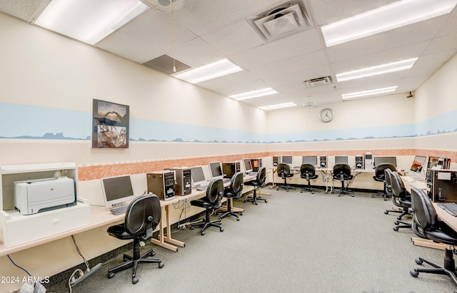 carpeted office space featuring a paneled ceiling