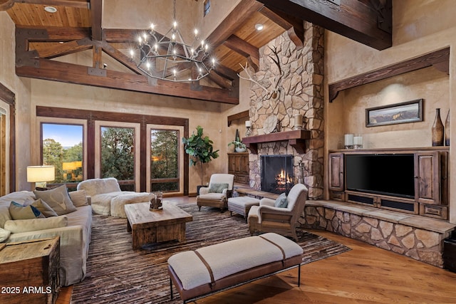 living room featuring wood ceiling, a stone fireplace, wood-type flooring, high vaulted ceiling, and beam ceiling