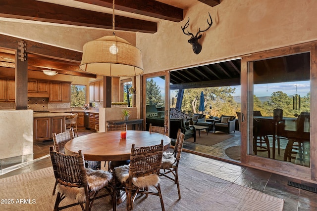 dining area with beam ceiling