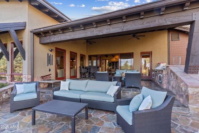 view of patio / terrace featuring ceiling fan, an outdoor hangout area, area for grilling, and exterior kitchen