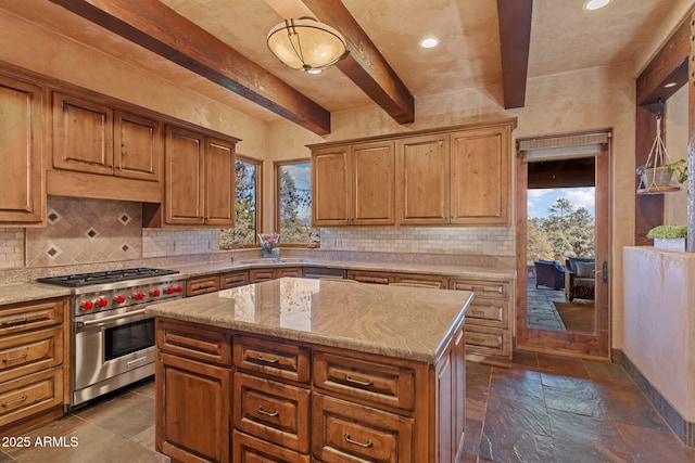 kitchen with light stone counters, premium range, tasteful backsplash, a kitchen island, and beam ceiling