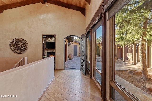 hallway featuring wood ceiling, light hardwood / wood-style flooring, and vaulted ceiling with beams