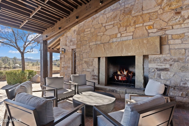 view of patio / terrace with an outdoor living space with a fireplace and a mountain view