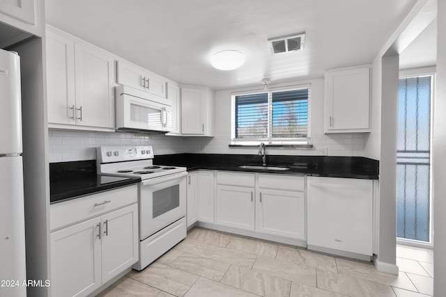 kitchen with white cabinets, white appliances, sink, and backsplash