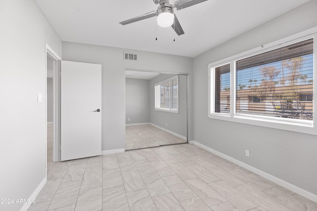 unfurnished bedroom featuring ceiling fan and a closet