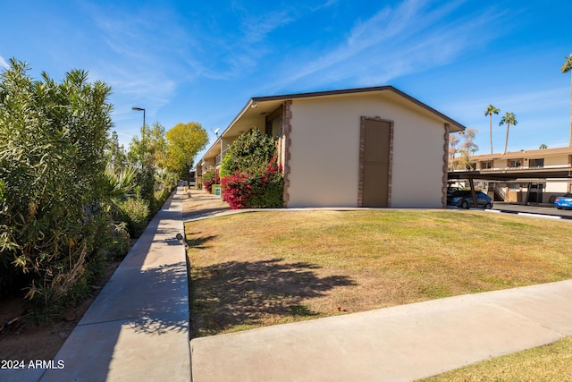 4701 N 68th St Unit 248, Scottsdale, AZ 85251 - view of side of home with stucco siding and a lawn