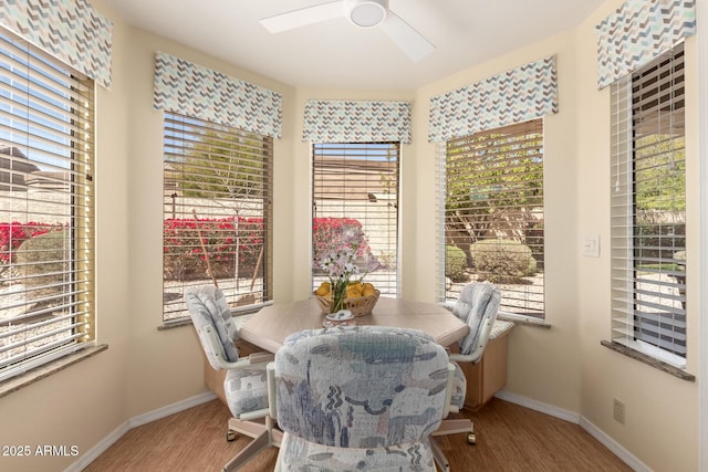 dining space featuring a ceiling fan, wood finished floors, and baseboards