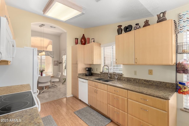 kitchen featuring white appliances, light brown cabinets, light wood-style flooring, a sink, and a notable chandelier