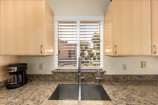 kitchen with a sink and light stone counters