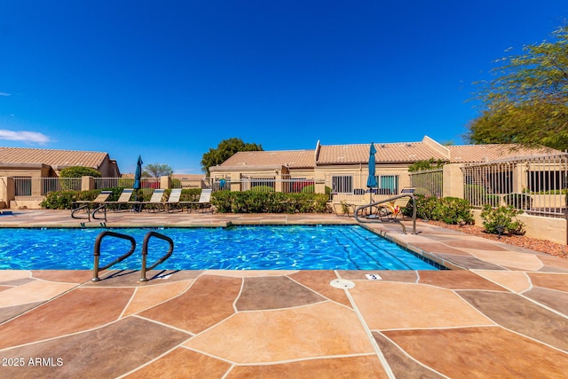 community pool featuring a patio and fence