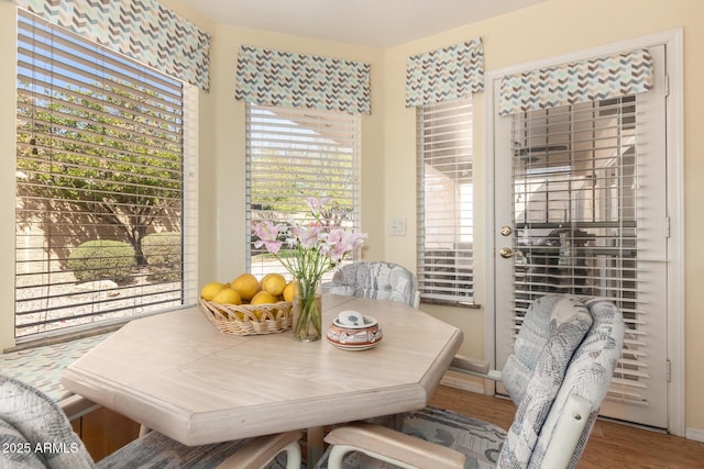 dining area with baseboards and wood finished floors