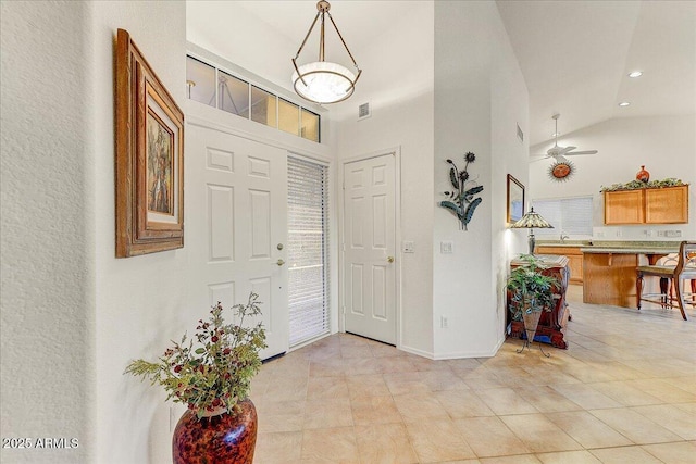 entrance foyer featuring ceiling fan, light tile patterned floors, and high vaulted ceiling