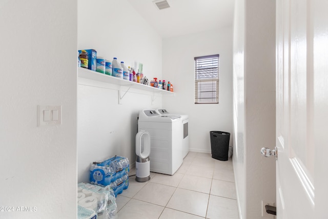 clothes washing area featuring light tile patterned flooring and washing machine and clothes dryer