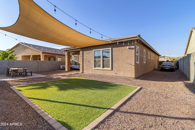 rear view of house featuring a patio area and a lawn