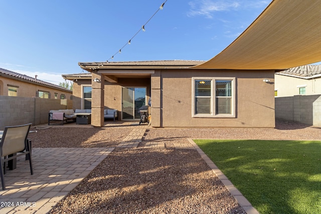 rear view of house with a patio area, a yard, and an outdoor hangout area