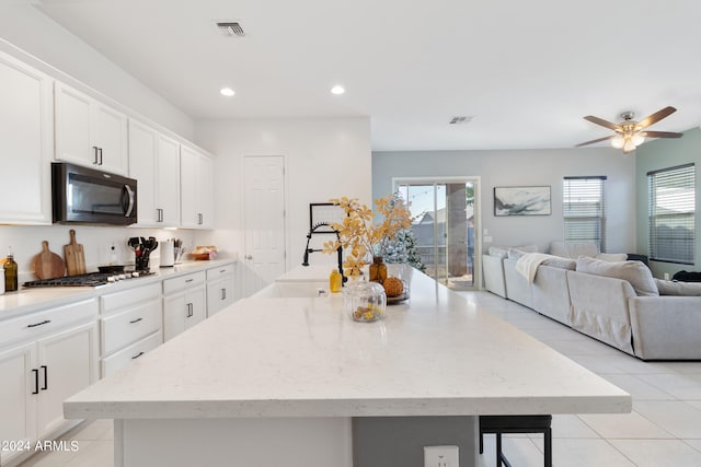 kitchen with white cabinetry, stainless steel appliances, a center island with sink, and sink