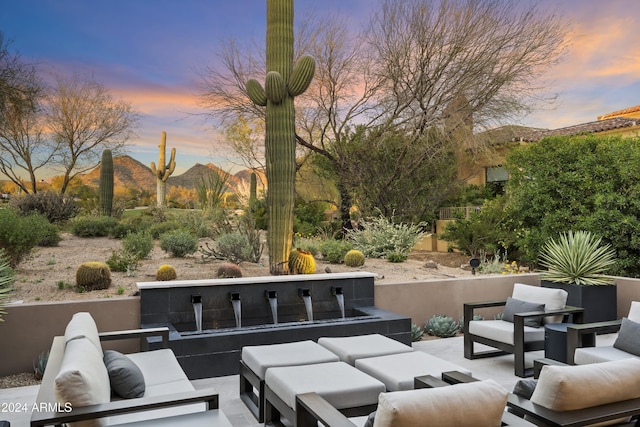 patio terrace at dusk with outdoor lounge area and a mountain view