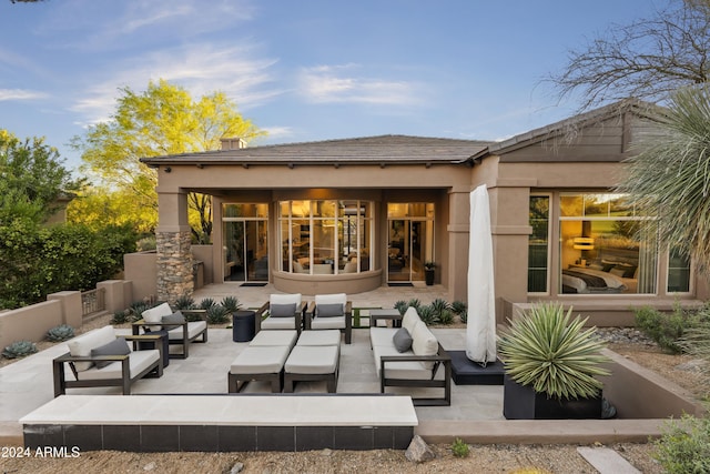 rear view of property featuring a patio area and an outdoor living space