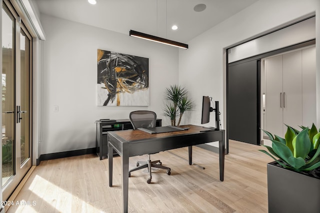 home office with light hardwood / wood-style flooring and french doors