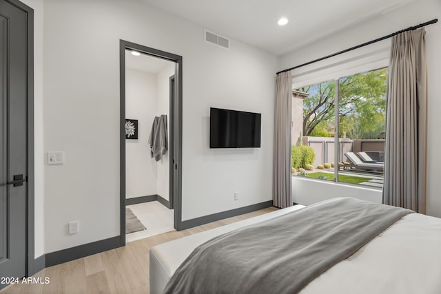 bedroom featuring ensuite bath and light hardwood / wood-style flooring