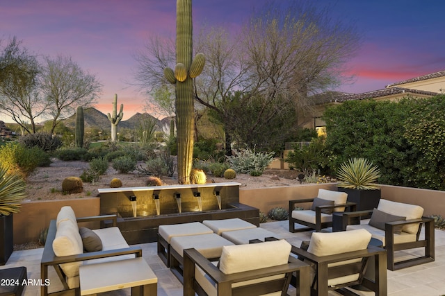 patio terrace at dusk with outdoor lounge area and a mountain view