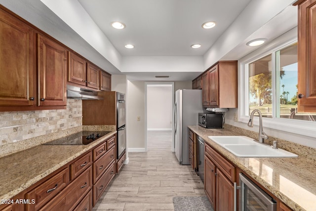 kitchen featuring sink, tasteful backsplash, wine cooler, light hardwood / wood-style flooring, and appliances with stainless steel finishes