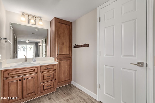 bathroom with hardwood / wood-style floors, vanity, and ceiling fan