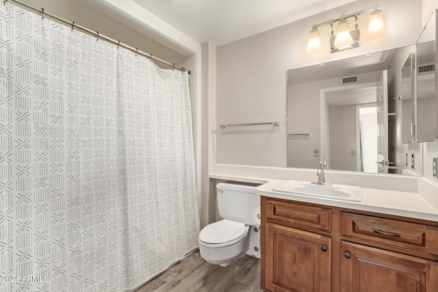 bathroom with wood-type flooring, vanity, and toilet