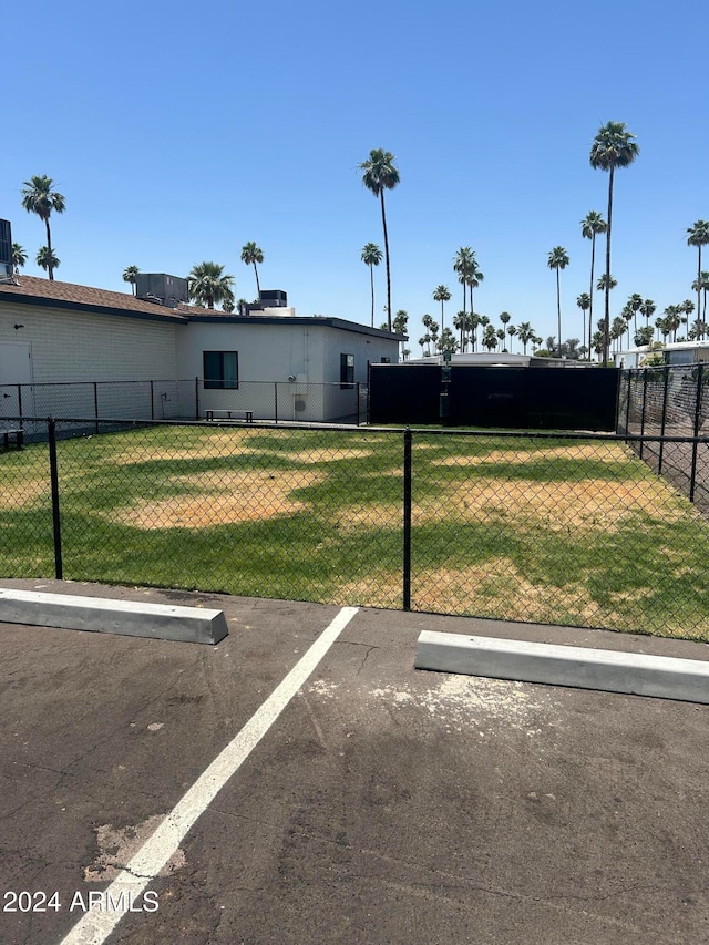 view of parking / parking lot with a lawn