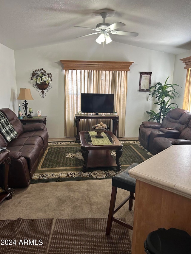 living room featuring lofted ceiling, carpet, a textured ceiling, and ceiling fan