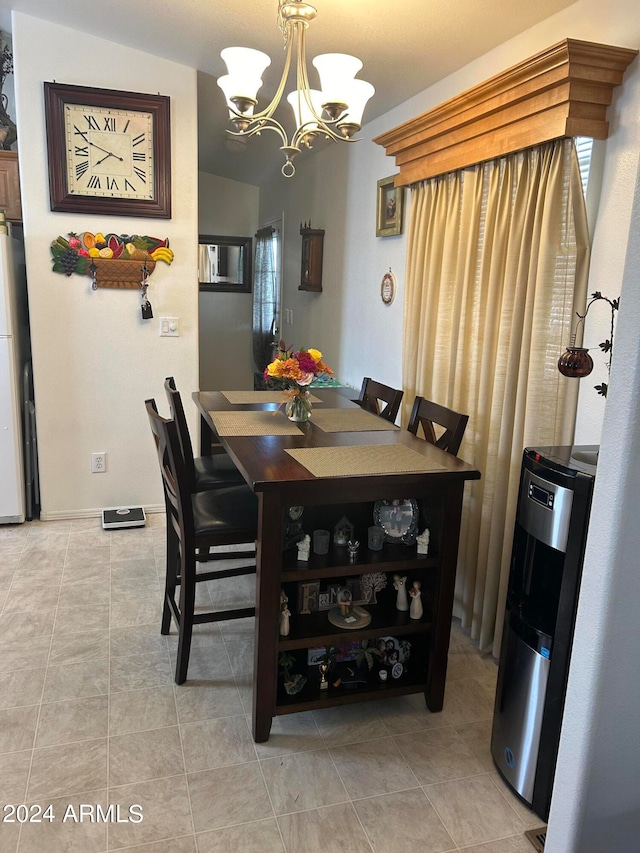 tiled dining area featuring an inviting chandelier