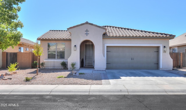 mediterranean / spanish-style house featuring stucco siding, concrete driveway, fence, a garage, and a tiled roof