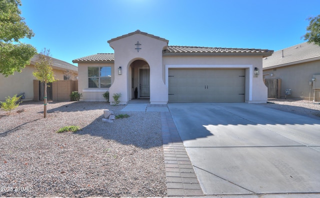 mediterranean / spanish-style house featuring a garage, driveway, a tile roof, fence, and stucco siding