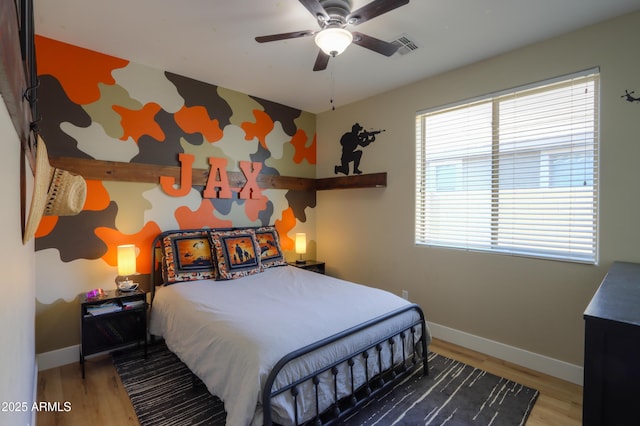 bedroom with ceiling fan, light wood-style flooring, and baseboards