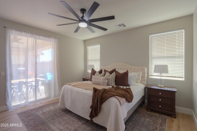 bedroom featuring light wood finished floors, multiple windows, visible vents, and access to exterior