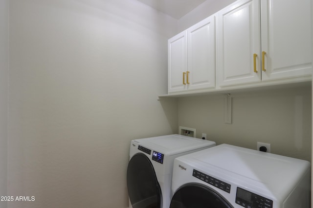 washroom featuring cabinet space and washing machine and clothes dryer