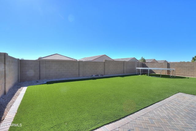 view of yard featuring a fenced backyard and a trampoline