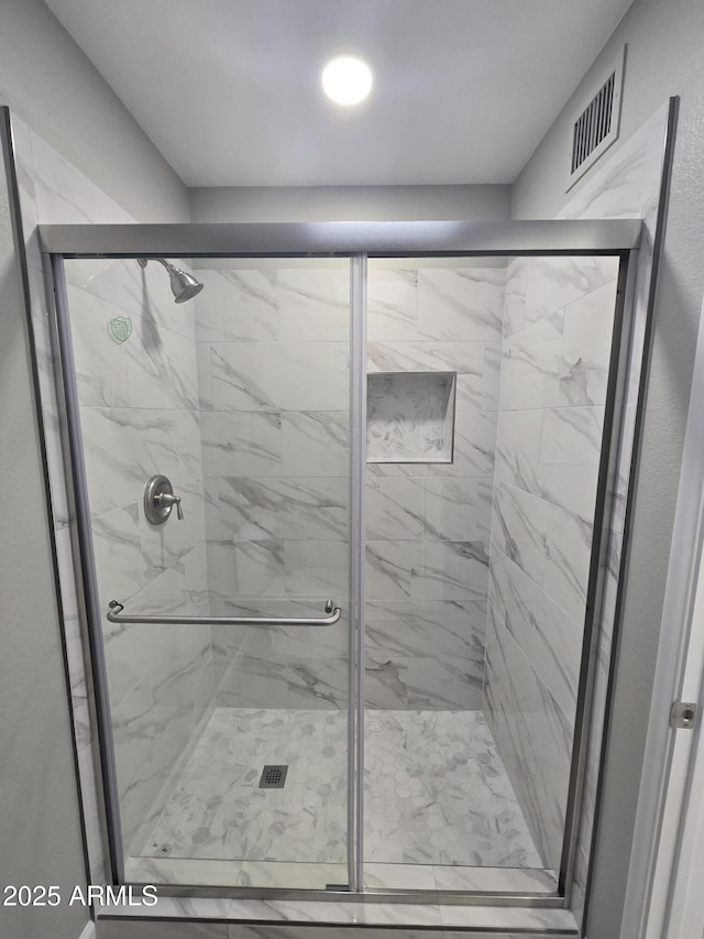 bathroom with visible vents and a shower stall