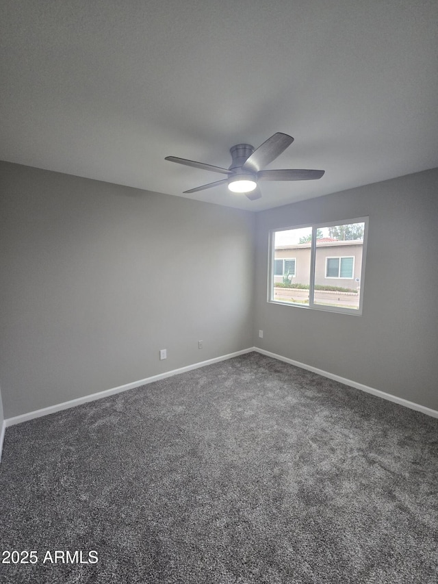 carpeted empty room with ceiling fan and baseboards