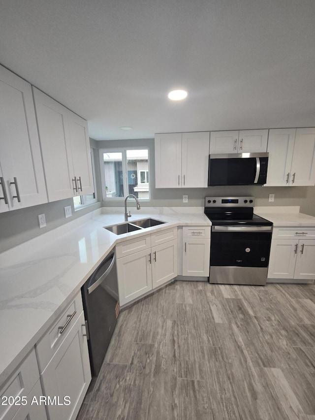 kitchen featuring white cabinetry, appliances with stainless steel finishes, and a sink