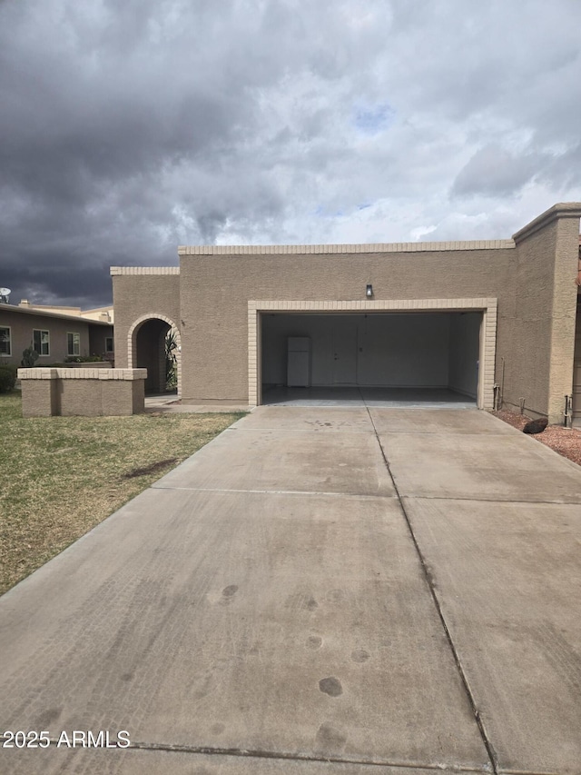 view of front of house with a garage, driveway, and stucco siding